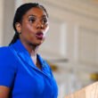 **Kemi Badenoch Facebook page owner speaking at a podium during a public event**