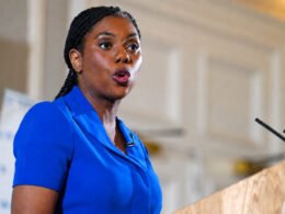 **Kemi Badenoch Facebook page owner speaking at a podium during a public event**