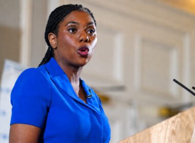 **Kemi Badenoch Facebook page owner speaking at a podium during a public event**