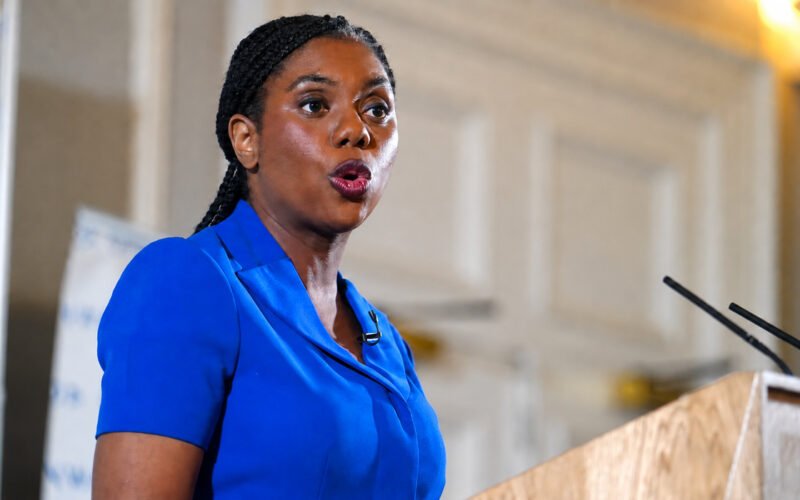 **Kemi Badenoch Facebook page owner speaking at a podium during a public event**